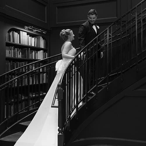 bride and groom on library staircase